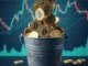Balde metálico com símbolo CASH3 transbordando moedas de bitcoin douradas com gráfico de trading ao fundo.
