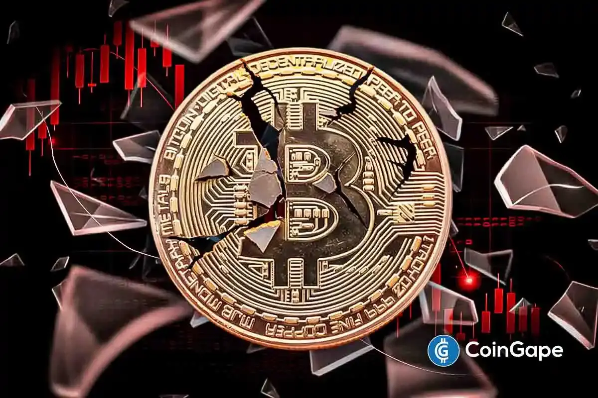 Moeda Bitcoin dourada fragmentada com gráfico de velas vermelhas ao fundo representando queda de preço.