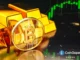 Moeda dourada do Bitcoin posicionada ao lado de barras de ouro com gráfico financeiro verde de alta no fundo.