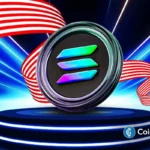Logo da Solana em medalha metálica sobre pedestal azul com bandeira americana ao fundo e feixes de luz azuis, representando aprovação de ETF nos EUA.