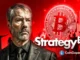Imagem promocional mostrando Michael Saylor com logo do Bitcoin e texto "Strategy" em fundo vermelho
