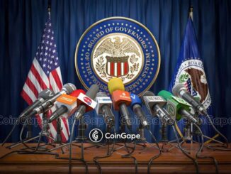 Sala de coletiva do Federal Reserve com múltiplos microfones da imprensa e selo oficial do Board of Governors