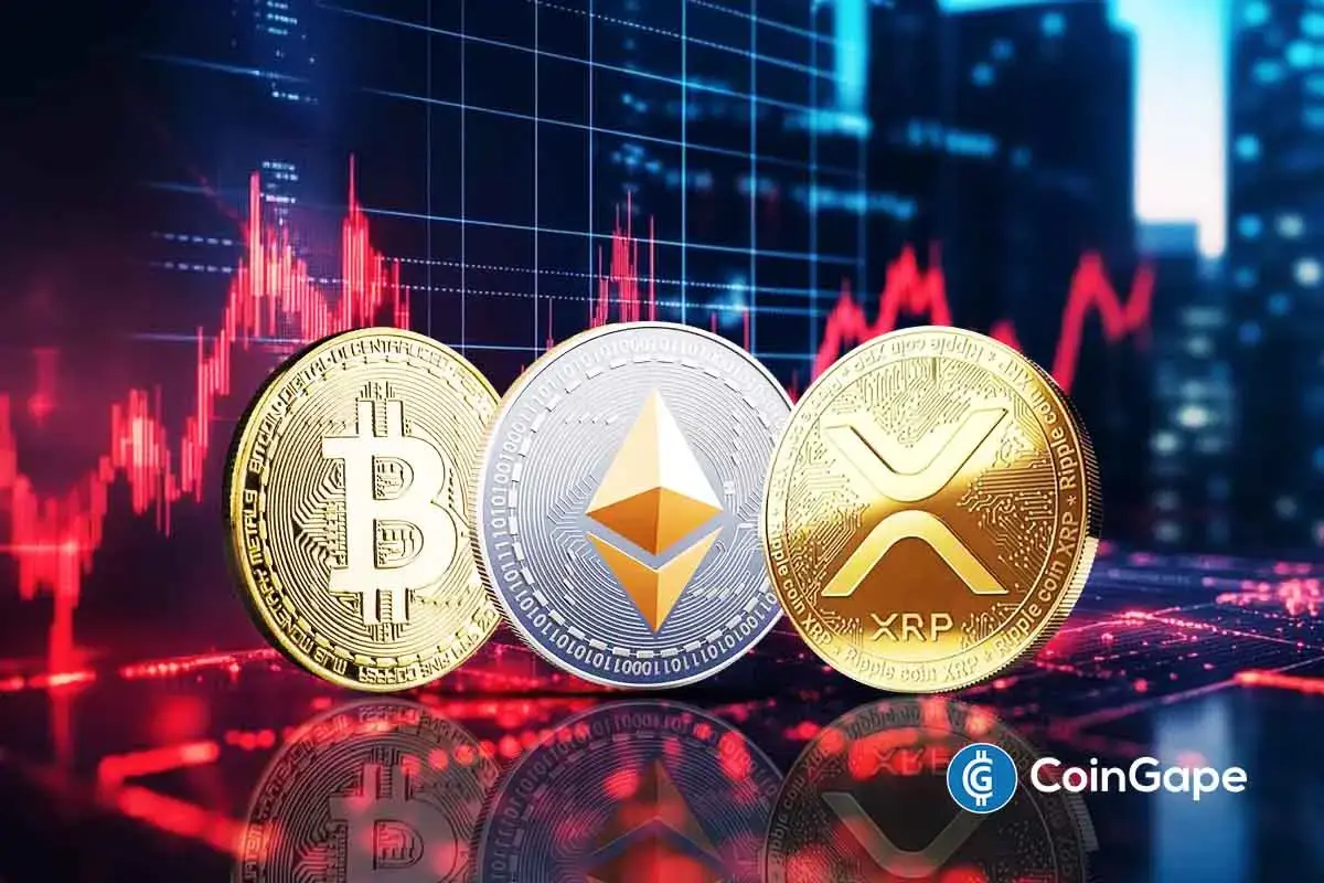 Moedas físicas de Bitcoin, Ethereum e XRP sobre gráficos de trading com candlesticks vermelhos.