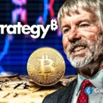 Michael Saylor sorrindo ao lado de moedas físicas de Bitcoin com logo da Strategy ao fundo